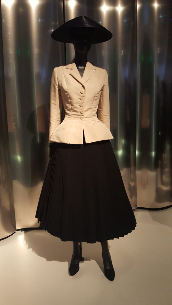 Cream fitted Bar jacket and black pleated skirt on a mannequin at the Denver Art Museum.