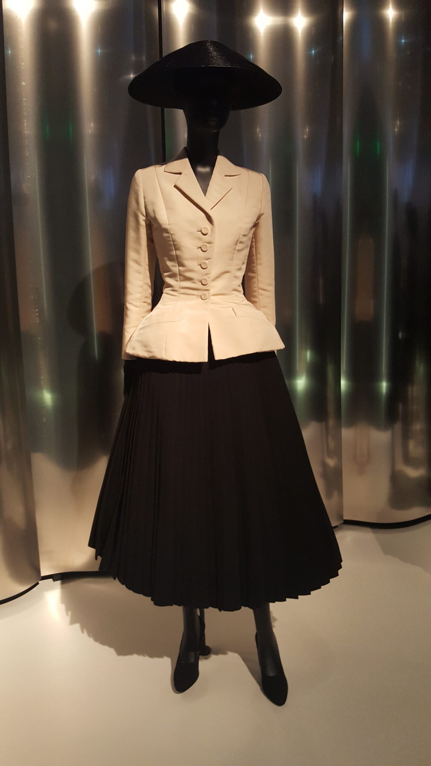 Cream fitted Bar jacket and black pleated skirt on a mannequin at the Denver Art Museum.